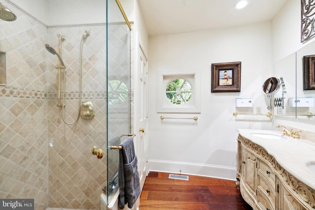 9791 Pintail Pl, Saint Michaels, MD 21663 - bathroom with wood finished floors, double vanity, baseboards, a tile shower, and recessed lighting