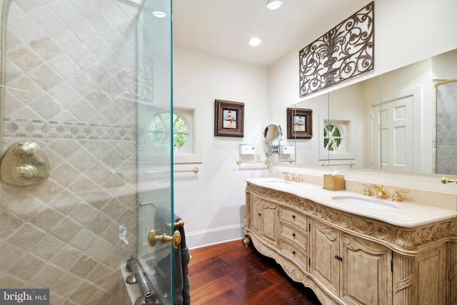 9791 Pintail Pl, Saint Michaels, MD 21663 - bathroom featuring wood-type flooring, baseboards, double vanity, tiled shower, and recessed lighting