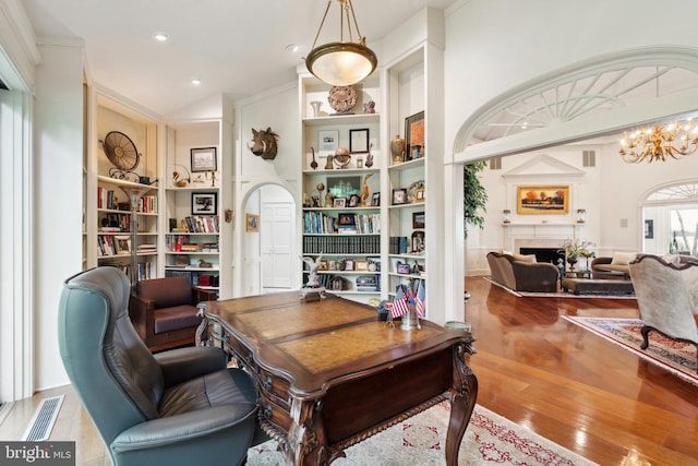 9791 Pintail Pl, Saint Michaels, MD 21663 - office space featuring wood finished floors, built in shelves, a fireplace, a chandelier, and recessed lighting