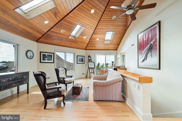 9791 Pintail Pl, Saint Michaels, MD 21663 - living room with a skylight, baseboards, light wood finished floors, ceiling fan, and high vaulted ceiling