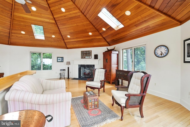 9791 Pintail Pl, Saint Michaels, MD 21663 - living room featuring a skylight, wood ceiling, a fireplace with flush hearth, light wood-style flooring, and recessed lighting