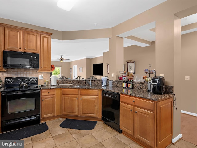 900 Marshy Cv Unit 111, Cambridge, MD 21613 - kitchen with black appliances, light tile patterned floors, a sink, dark stone countertops, and brown cabinetry