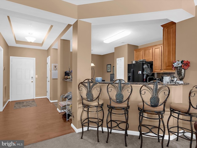 900 Marshy Cv Unit 111, Cambridge, MD 21613 - kitchen featuring black fridge with ice dispenser, a kitchen breakfast bar, a peninsula, and baseboards