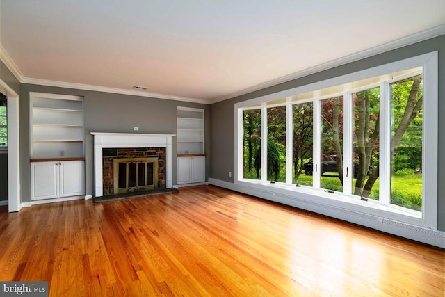 2410 Huntingdon Rd, Huntingdon Valley, PA 19006 - unfurnished living room featuring plenty of natural light, a stone fireplace, wood finished floors, and ornamental molding