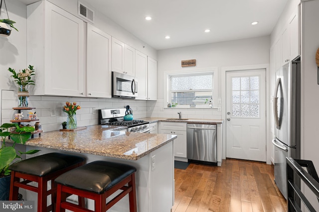 2117 Latona St, Philadelphia, PA 19146 - kitchen with appliances with stainless steel finishes, a peninsula, a sink, light wood finished floors, and recessed lighting