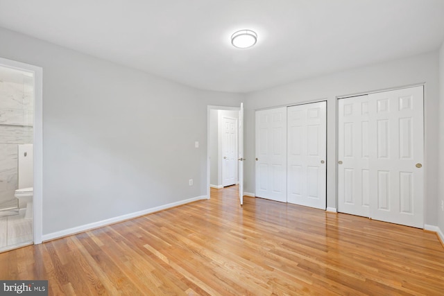 1515 Ainsley Rd, Silver Spring, MD 20904 - unfurnished bedroom with multiple closets, light wood-style floors, baseboards, and ensuite bathroom
