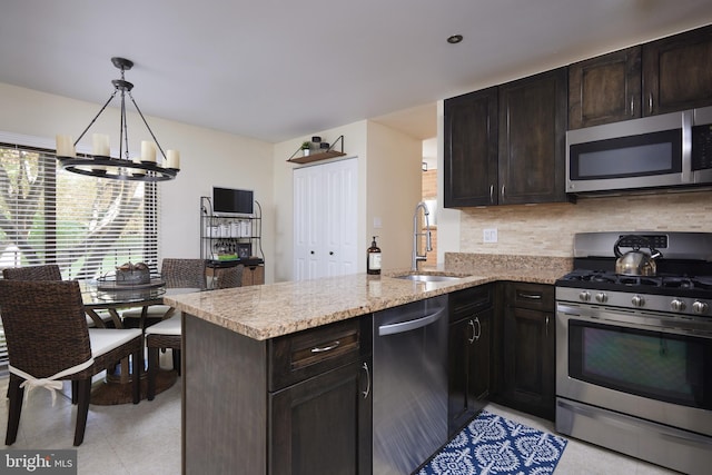 10893 Deborah Dr, Potomac, MD 20854 - kitchen with appliances with stainless steel finishes, a sink, a peninsula, tasteful backsplash, and a chandelier