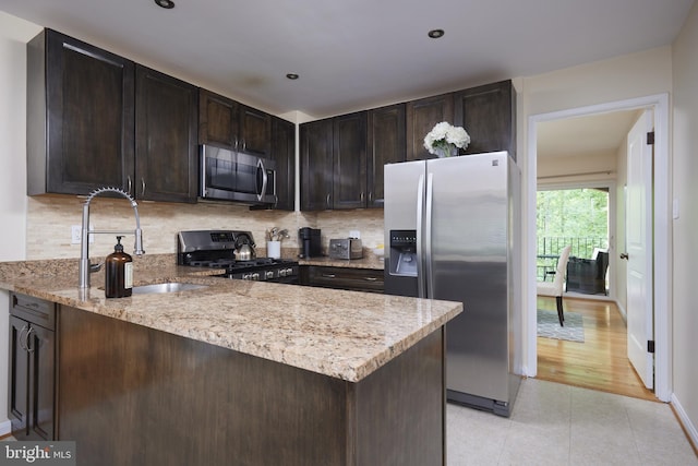 10893 Deborah Dr, Potomac, MD 20854 - kitchen featuring stainless steel appliances, backsplash, dark brown cabinetry, a peninsula, and recessed lighting
