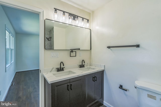 13029 Clarion Rd, Fort Washington, MD 20744 - full bath featuring double vanity, toilet, baseboards, and wood finished floors