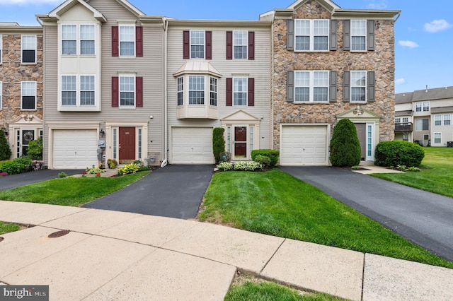 233 Windsor Ct, Quakertown, PA 18951 - townhome / multi-family property featuring driveway, stone siding, an attached garage, and a front lawn