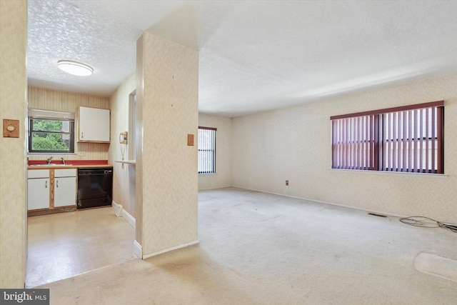 9363 Neil Rd Unit A, Philadelphia, PA 19115 - kitchen with black dishwasher, plenty of natural light, a textured ceiling, white cabinets, and a sink
