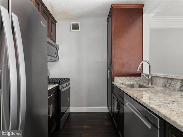4141 N Henderson Rd N Unit 809, Arlington, VA 22203 - kitchen featuring appliances with stainless steel finishes, a sink, dark wood-type flooring, light stone countertops, and a textured ceiling