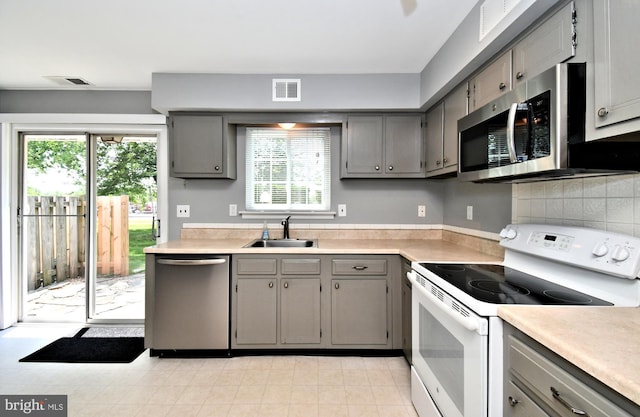 313 Christopher Ct, Lansdale, PA 19446 - kitchen with appliances with stainless steel finishes, gray cabinetry, a sink, and plenty of natural light