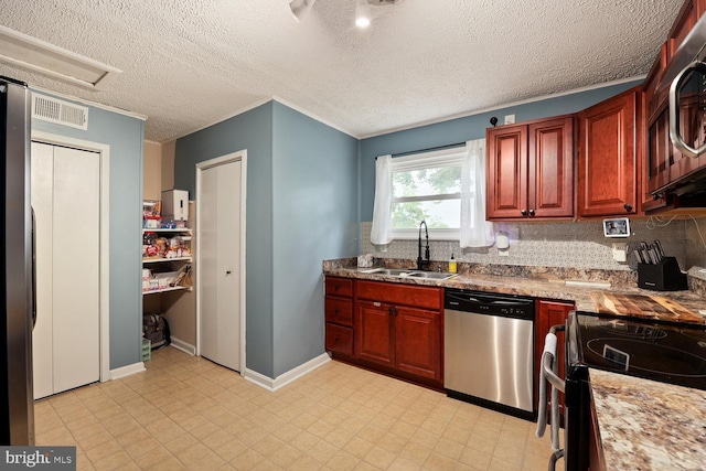 35 Holly Corner Rd, Fredericksburg, VA 22406 - kitchen with appliances with stainless steel finishes, a sink, decorative backsplash, a textured ceiling, and baseboards