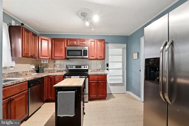 35 Holly Corner Rd, Fredericksburg, VA 22406 - kitchen with appliances with stainless steel finishes, a textured ceiling, backsplash, wooden counters, and baseboards