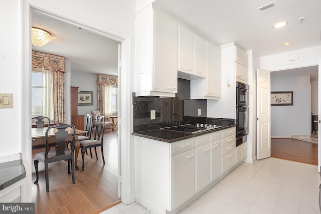 3801 Canterbury Rd Unit 817, Baltimore, MD 21218 - kitchen featuring black appliances, white cabinets, tasteful backsplash, a warming drawer, and light wood-style floors