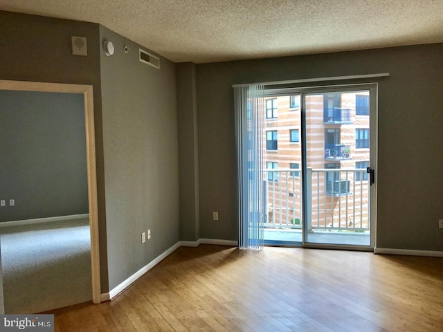 1111 11th St NW Unit 307, Washington, DC 20001 - unfurnished room with wood finished floors, a textured ceiling, baseboards, and a smoke detector