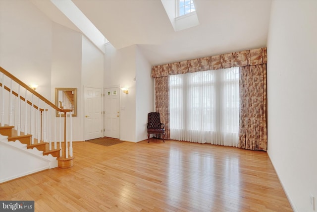 259 Prospect Cir Unit 8, Shrewsbury, PA 17361 - unfurnished living room featuring high vaulted ceiling, wood finished floors, stairway, and a skylight