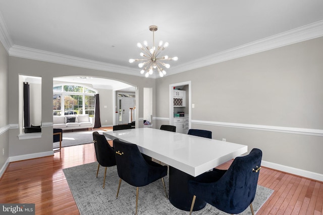 12801 Willow Marsh Ln, Bowie, MD 20720 - dining room with arched walkways, ornamental molding, baseboards, hardwood / wood-style floors, and a chandelier