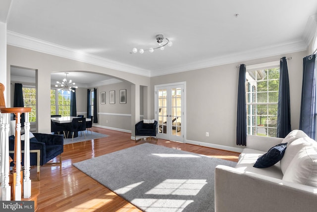 12801 Willow Marsh Ln, Bowie, MD 20720 - living room with a chandelier, arched walkways, crown molding, healthy amount of natural light, and wood finished floors