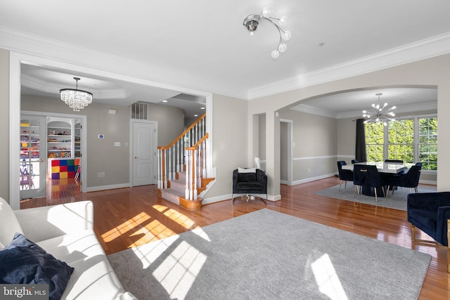 12801 Willow Marsh Ln, Bowie, MD 20720 - living area featuring a chandelier, arched walkways, ornamental molding, wood finished floors, and stairs