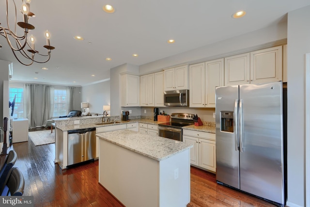 888 S Macon St, Baltimore, MD 21224 - kitchen featuring appliances with stainless steel finishes, a sink, open floor plan, light stone countertops, and a kitchen island