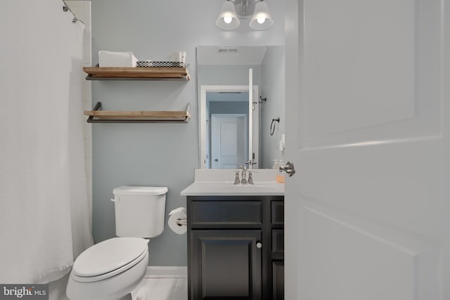 888 S Macon St, Baltimore, MD 21224 - full bathroom with toilet, vanity, a shower with curtain, and baseboards