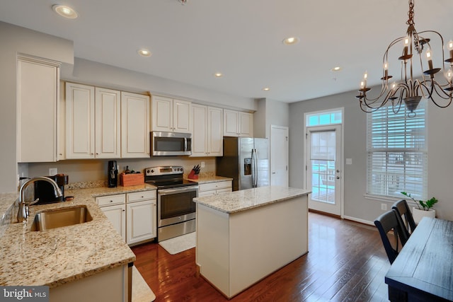 888 S Macon St, Baltimore, MD 21224 - kitchen featuring appliances with stainless steel finishes, a sink, a center island, dark wood-type flooring, and a chandelier