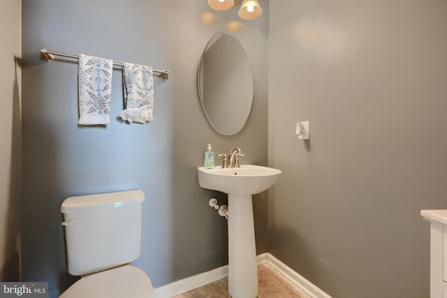 888 S Macon St, Baltimore, MD 21224 - half bath with toilet, tile patterned floors, and baseboards
