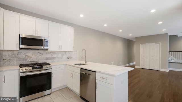 7804 Ardleigh St, Philadelphia, PA 19118 - kitchen featuring appliances with stainless steel finishes, a sink, a peninsula, recessed lighting, and decorative backsplash