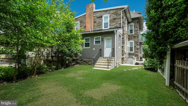 7804 Ardleigh St, Philadelphia, PA 19118 - rear view of property with entry steps, stone siding, stucco siding, and a chimney
