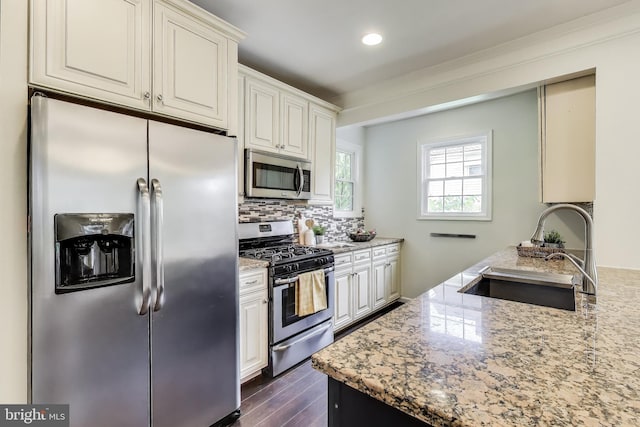 3404 Shepherd St, Mount Rainier, MD 20712 - kitchen featuring appliances with stainless steel finishes, a sink, light stone countertops, dark wood finished floors, and tasteful backsplash