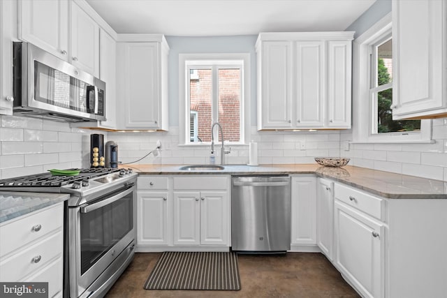 1408 Riverview Ave, Wilmington, DE 19806 - kitchen with appliances with stainless steel finishes, a sink, white cabinets, and plenty of natural light