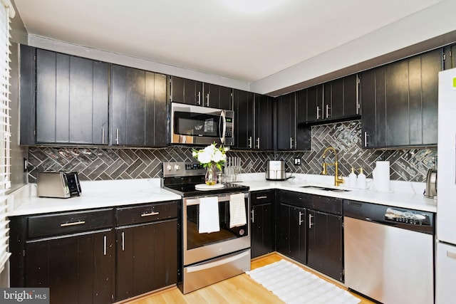 10 Bantry Ct, Baltimore, MD 21237 - kitchen with appliances with stainless steel finishes, a sink, tasteful backsplash, light countertops, and light wood-type flooring