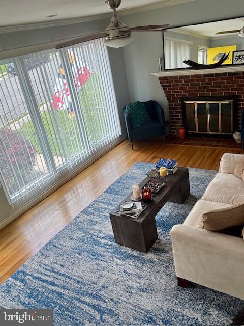 4116 Ellis St, Capitol Heights, MD 20743 - living area featuring a ceiling fan, crown molding, a fireplace, and wood finished floors