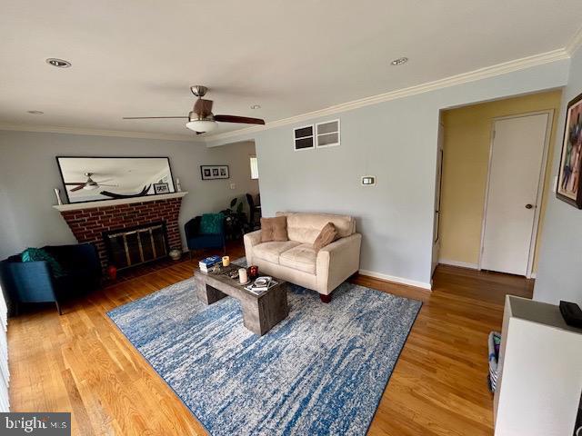 4116 Ellis St, Capitol Heights, MD 20743 - living area with ceiling fan, crown molding, wood finished floors, a fireplace, and baseboards
