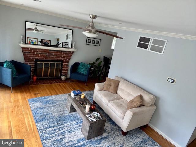 4116 Ellis St, Capitol Heights, MD 20743 - living room with ceiling fan, ornamental molding, wood finished floors, and a brick fireplace
