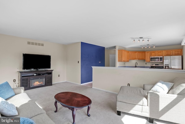 53 Pebble Beach Ln, Pottstown, PA 19464 - living area with light carpet, a glass covered fireplace, and baseboards