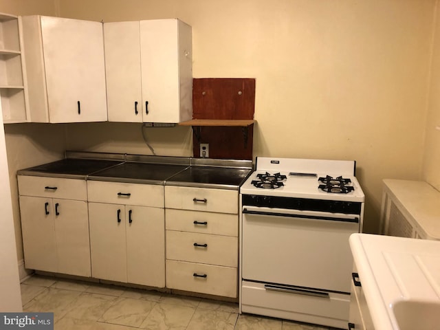 2312 Memphis St, Philadelphia, PA 19125 - kitchen featuring white range with gas stovetop, open shelves, light marble finish flooring, dark countertops, and white cabinets
