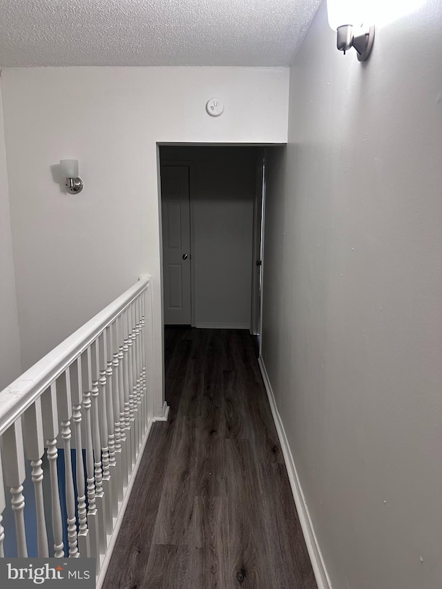 202 N Penn St, York, PA 17401 - corridor with wood finished floors, a textured ceiling, baseboards, and an upstairs landing