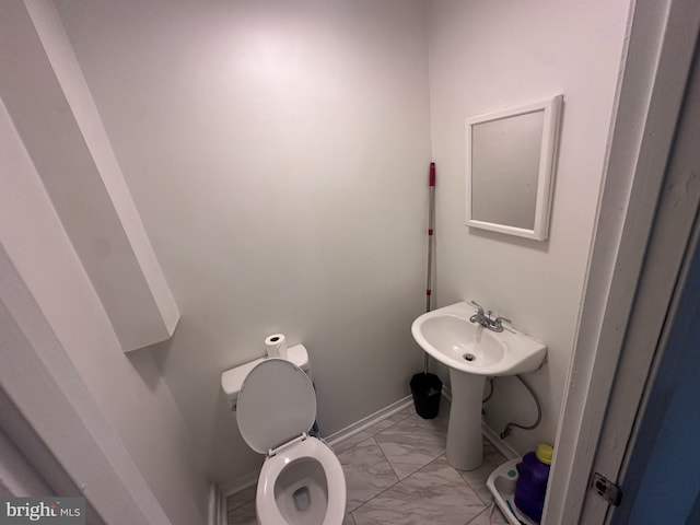 202 N Penn St, York, PA 17401 - half bathroom with marble finish floors, toilet, and baseboards