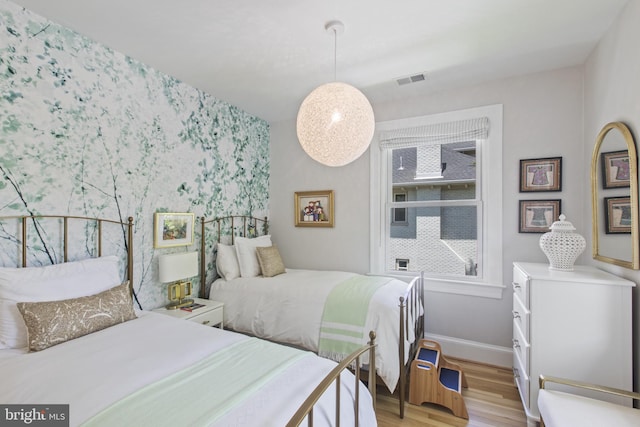 6200 Broad Branch Rd NW, Washington, DC 20015 - bedroom with light wood finished floors, wallpapered walls, baseboards, and an accent wall