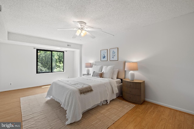 3800 Powell Ln Unit 629, Falls Church, VA 22041 - bedroom featuring a textured ceiling, light wood-style flooring, baseboards, and a ceiling fan