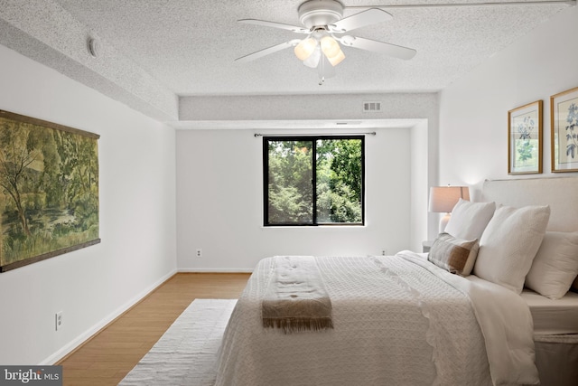 3800 Powell Ln Unit 629, Falls Church, VA 22041 - bedroom with light wood-style floors, a textured ceiling, ceiling fan, and baseboards
