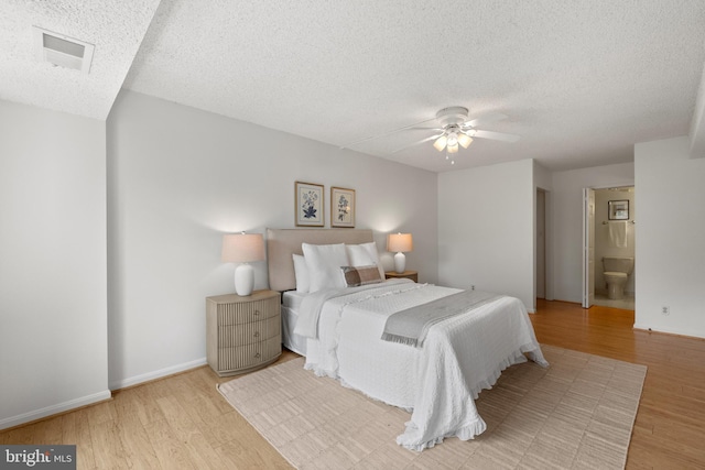 3800 Powell Ln Unit 629, Falls Church, VA 22041 - bedroom with a textured ceiling, wood finished floors, baseboards, ceiling fan, and ensuite bath