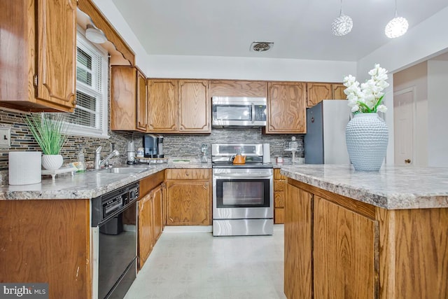 9803 Luke Ct, Upper Marlboro, MD 20772 - kitchen featuring appliances with stainless steel finishes, backsplash, brown cabinets, light floors, and hanging light fixtures