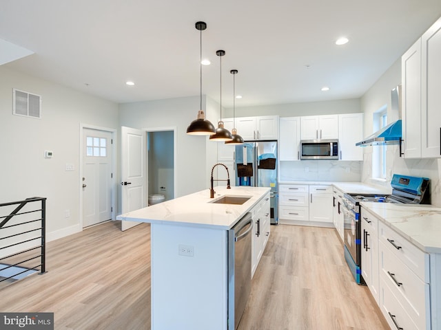 632 Moyer St, Philadelphia, PA 19125 - kitchen with appliances with stainless steel finishes, a sink, light wood-type flooring, white cabinets, and tasteful backsplash