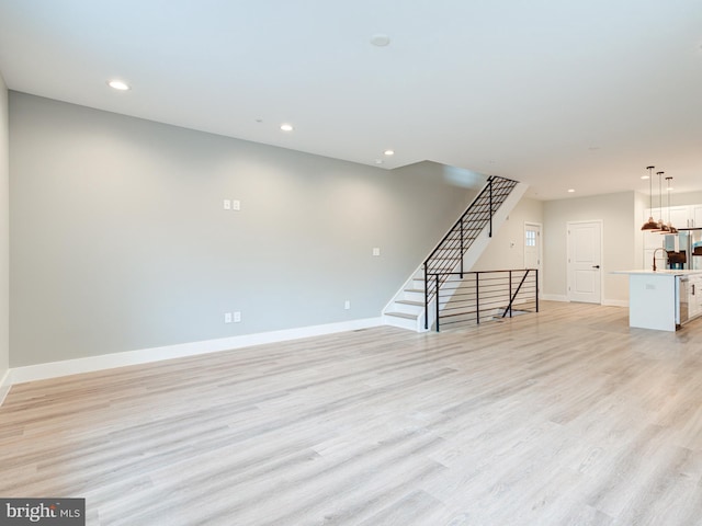 632 Moyer St, Philadelphia, PA 19125 - unfurnished living room featuring baseboards, recessed lighting, light wood-style flooring, stairs, and a sink