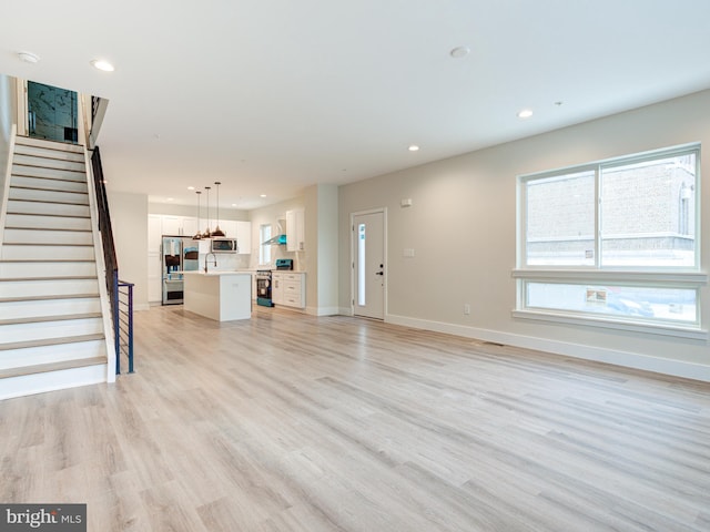632 Moyer St, Philadelphia, PA 19125 - unfurnished living room with light wood-style flooring, recessed lighting, stairs, baseboards, and a sink