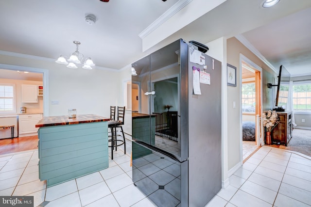 54 Camellia Rd, Levittown, PA 19057 - kitchen featuring crown molding, light tile patterned flooring, a chandelier, butcher block counters, and baseboards